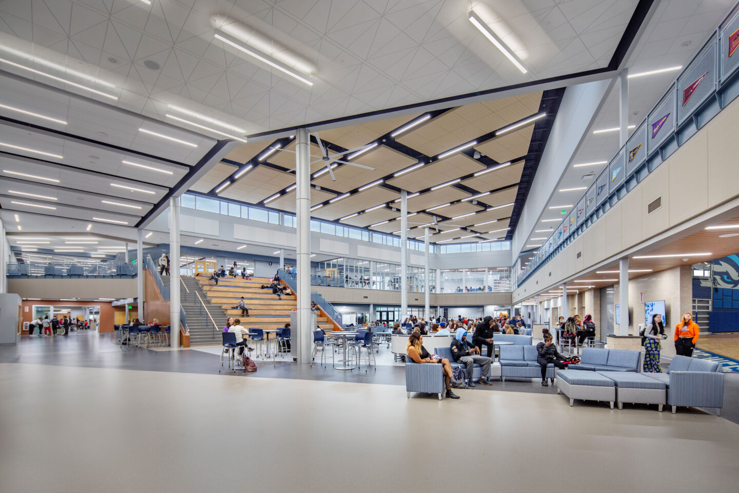 Cafeteria with vaulted, intricate ceilings, connected to collaboration spaces and a learning stair