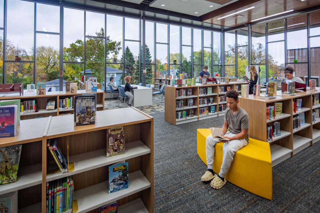 Library at Vel Phillips Middle School looking out the floor to ceiling windows over the entrance of the building.