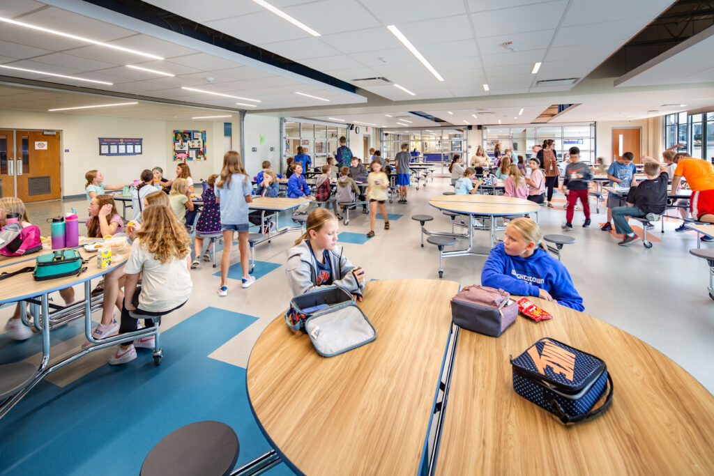 Wrightstown middle school cafeteria with garage doors to the servery closed and one garage door to the corridor open