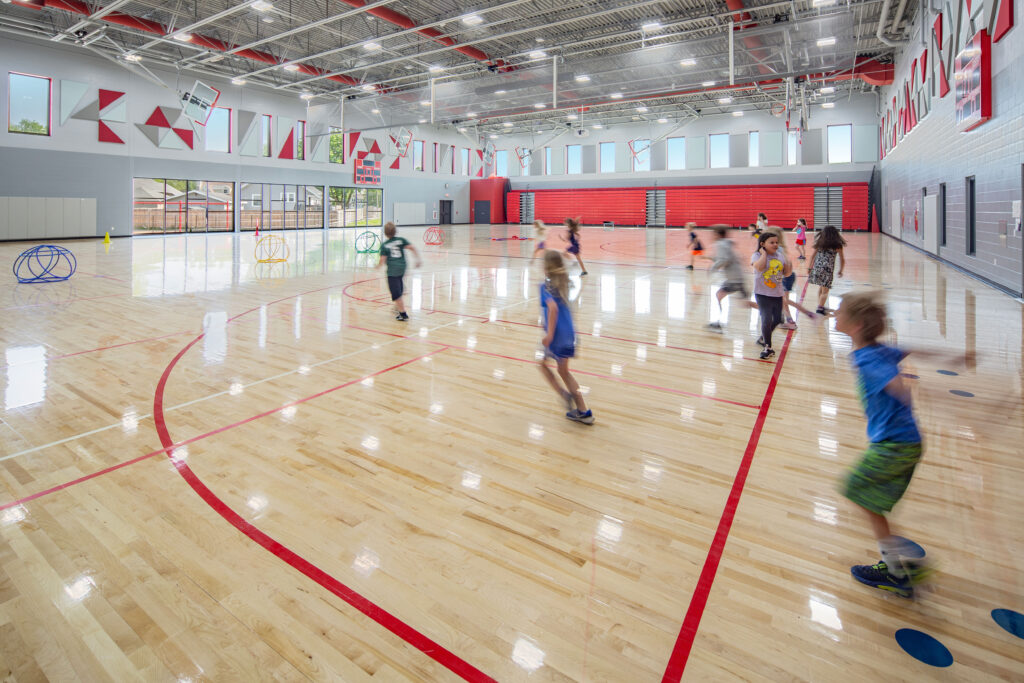 Gymnasium with exterior ample natural light through windows at Columbus Elementary School