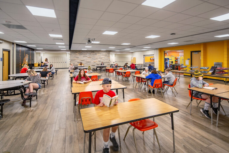 Cafeteria at Theisen Middle School with a brick accent wall.