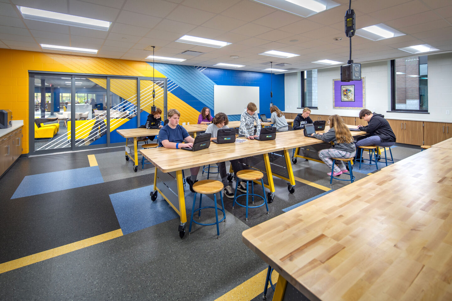 Maker space room with branded wall and glass doors that slide open to the production area