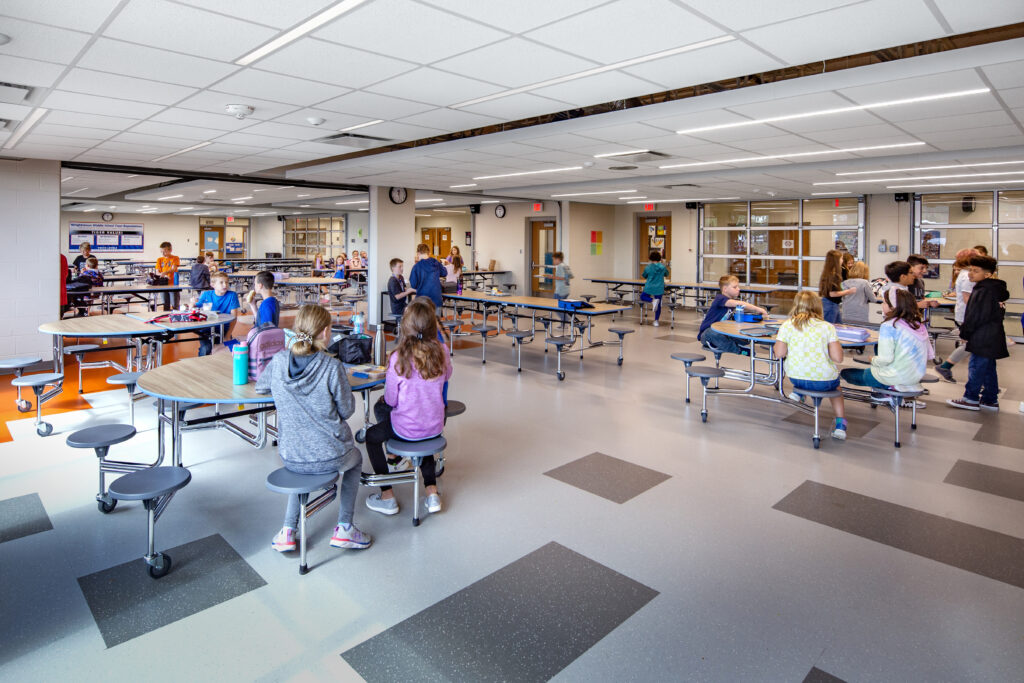 Wrightstown middle school cafeteria with garage doors to the corridor closed and students eating lunch