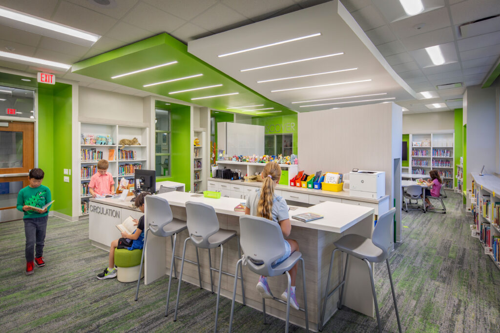 Cumberland Elementary School Library circulation desk with students reading