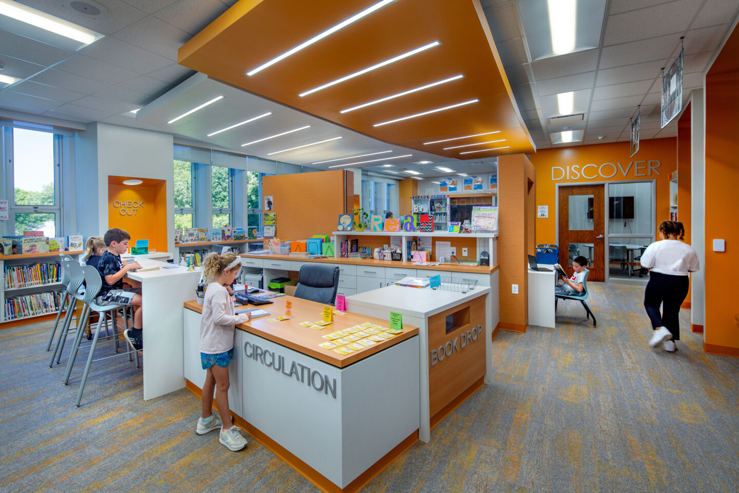 Richards Elementary School library circulation desk with students reading