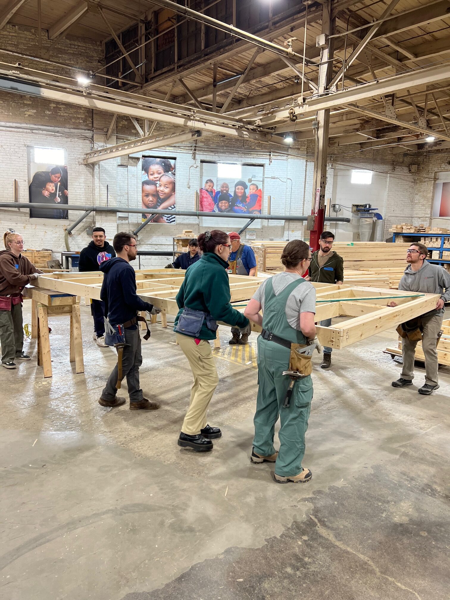 Group of bray employees carrying wall panels at volunteer day