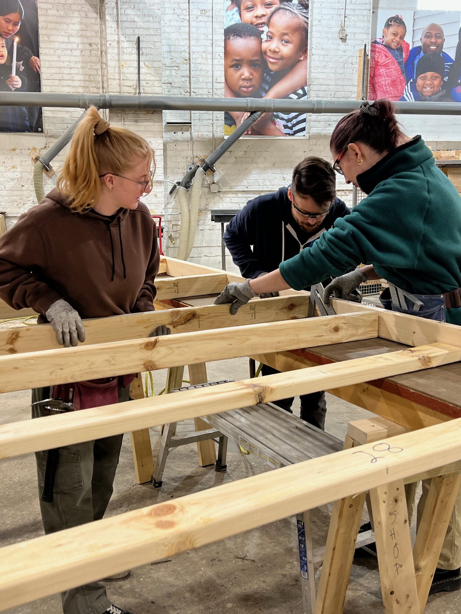 Three team members working together on making wall panels at volunteer day