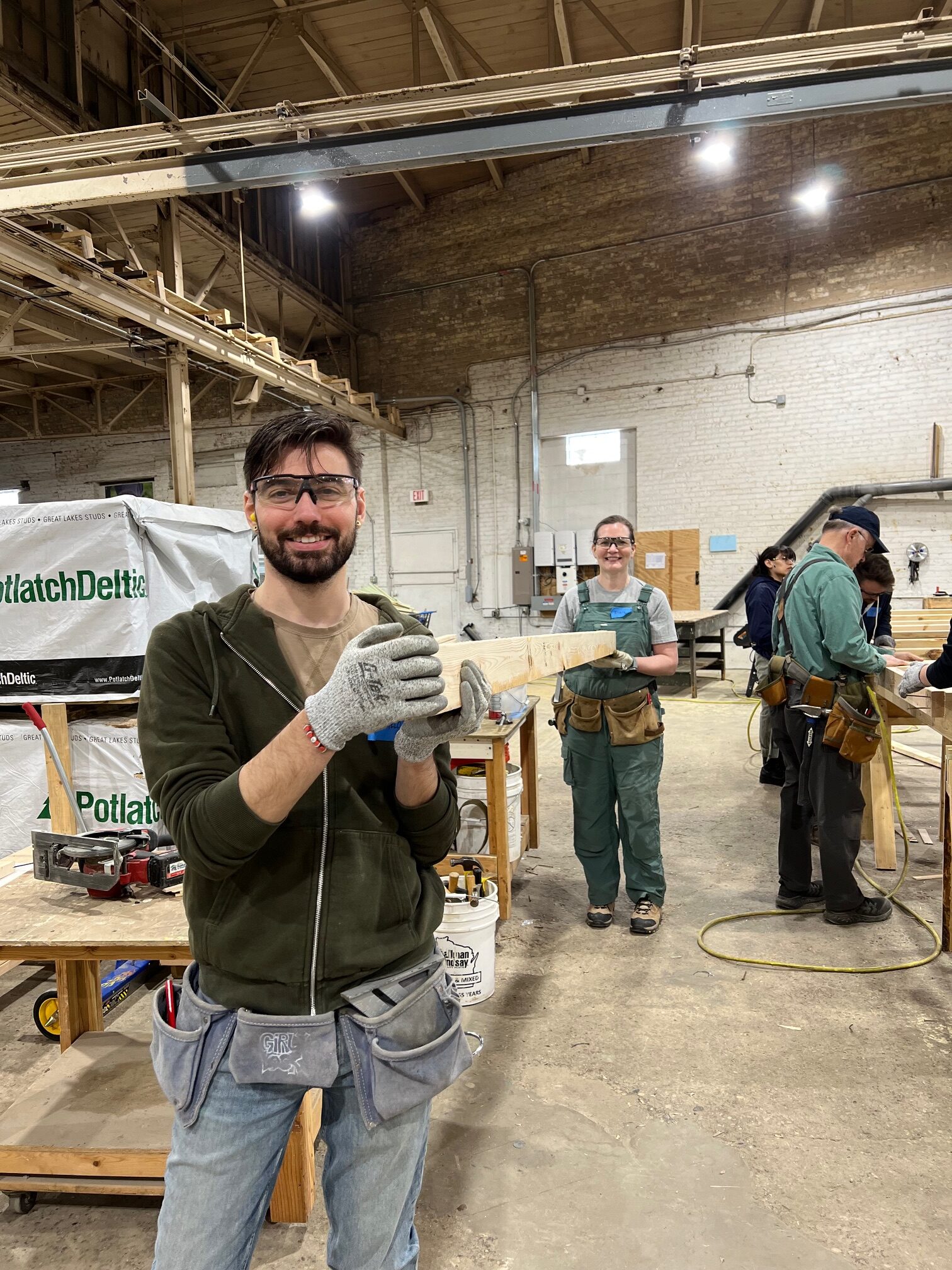 Two team members carrying wood at volunteer day