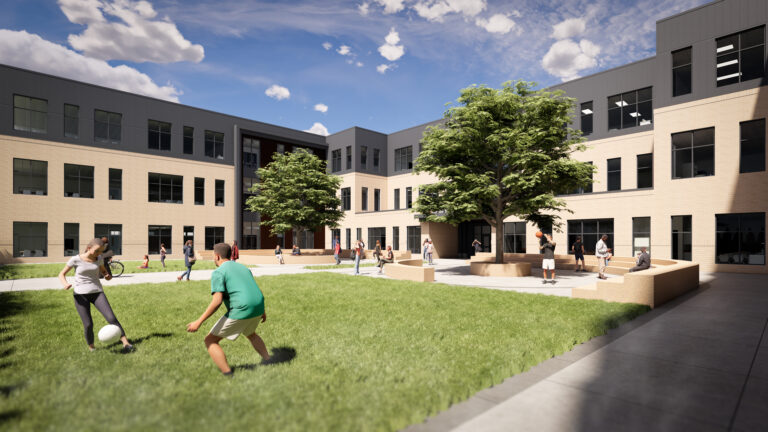 Students playing in the grass and sitting the outdoor classroom spaces